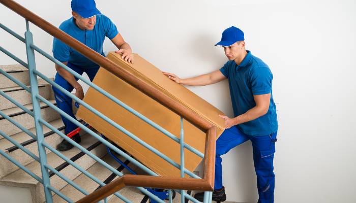 Arthur Perez Movers - Moving couch upstairs blue shirts
